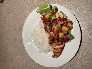 Grilled lime salmon with mango avocado salsa and coconut rice on a table. The meal is promoting Healthy Eating for Healthy Eyes