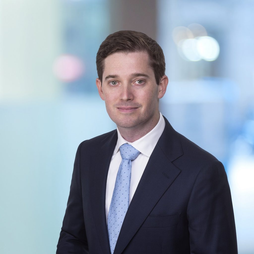 Profile photo of Dr Geoffrey Ryan wearing blue tie and dark blue suit looking at camera