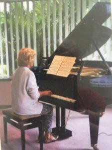 Sideview of Giselle playing piano